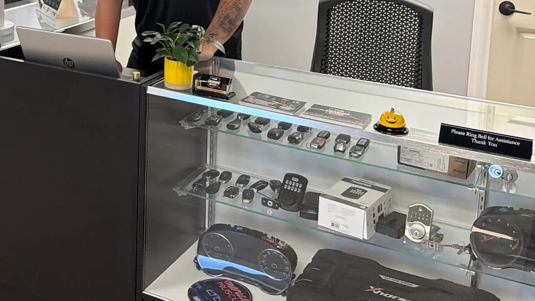 Keypad deadbolts and a smart lock in the display case at The Locksmith Shop in South Tampa, with car key fobs on the shelf above